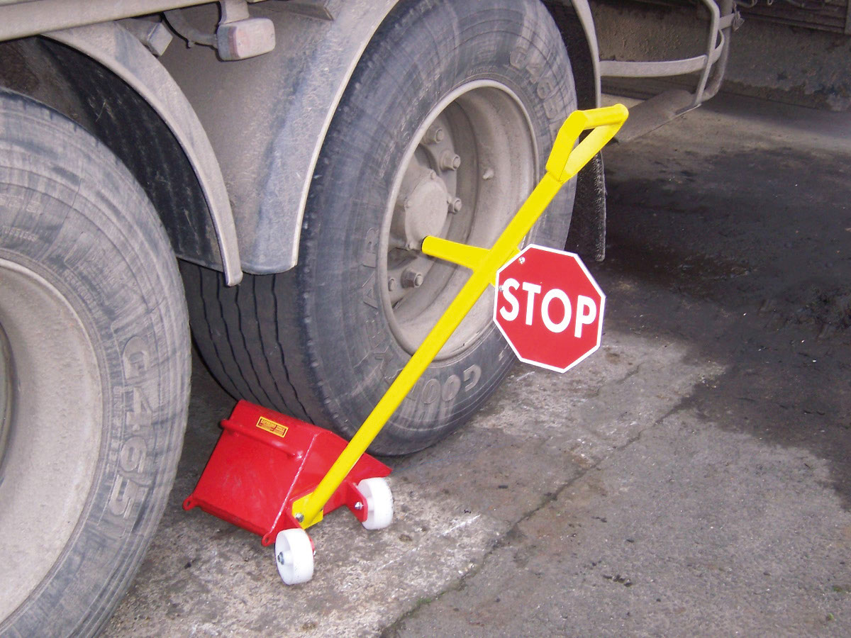 La cale de roue avec panneau STOP et chaîne antivol pour camion